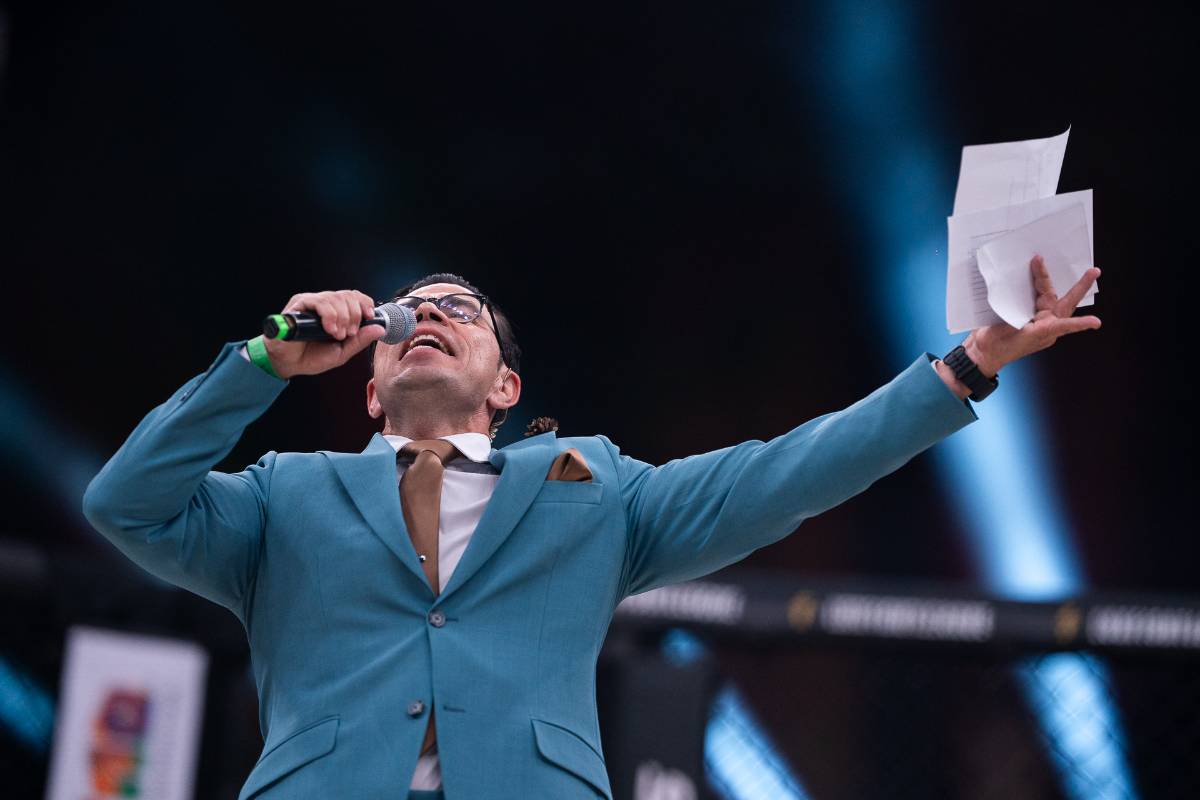 Felipe DeMaria con los brazos abiertos, dirigiéndose al público